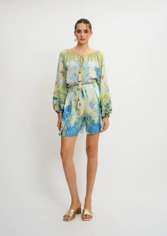 Model wearing Pleated Aura Shorts in Jardin du Jour print by Koré Collections