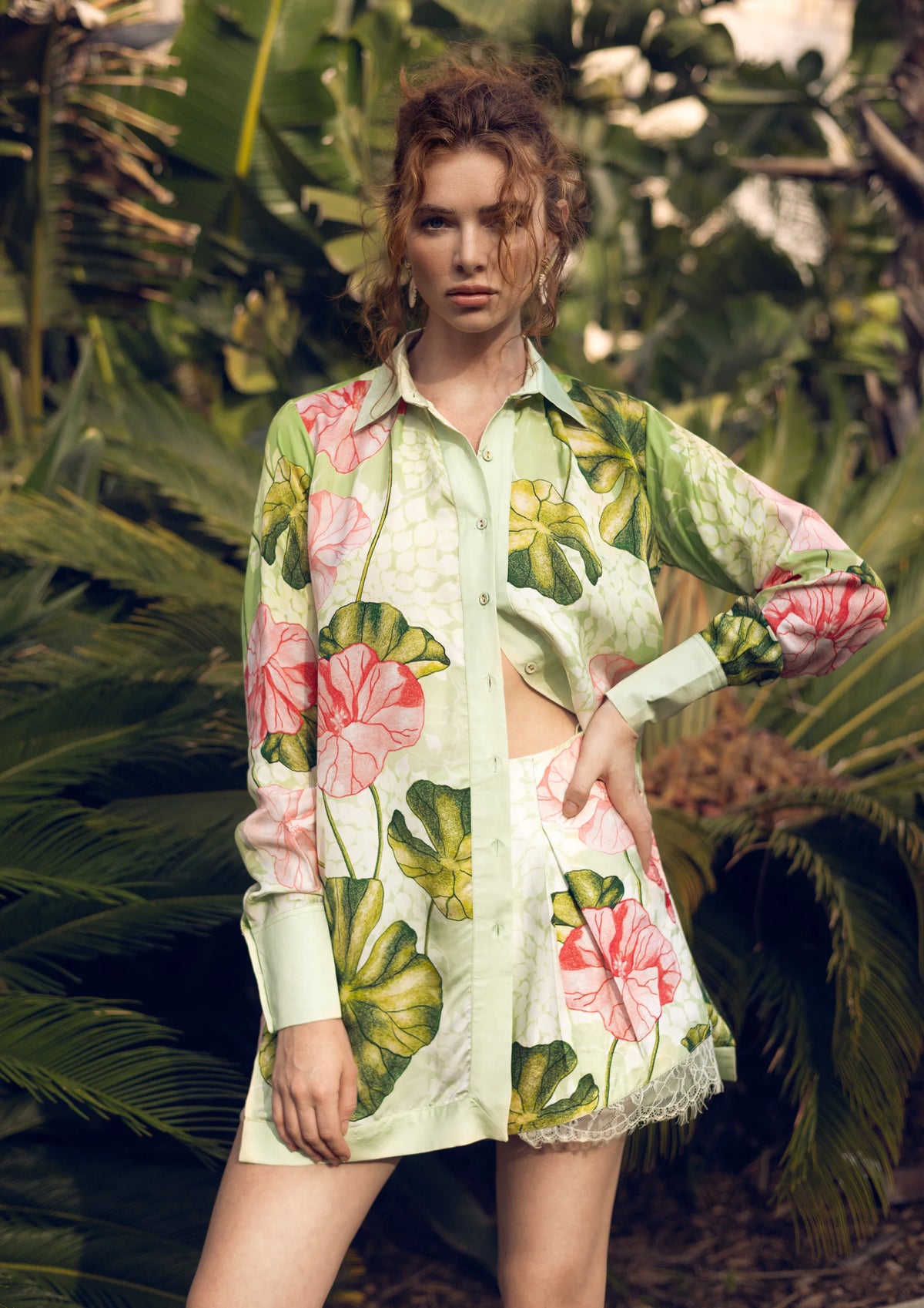 Woman wearing a Koré Collections floral outfit standing among tropical plants